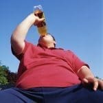 Overweight Teenage Man Drinking From a Bottle