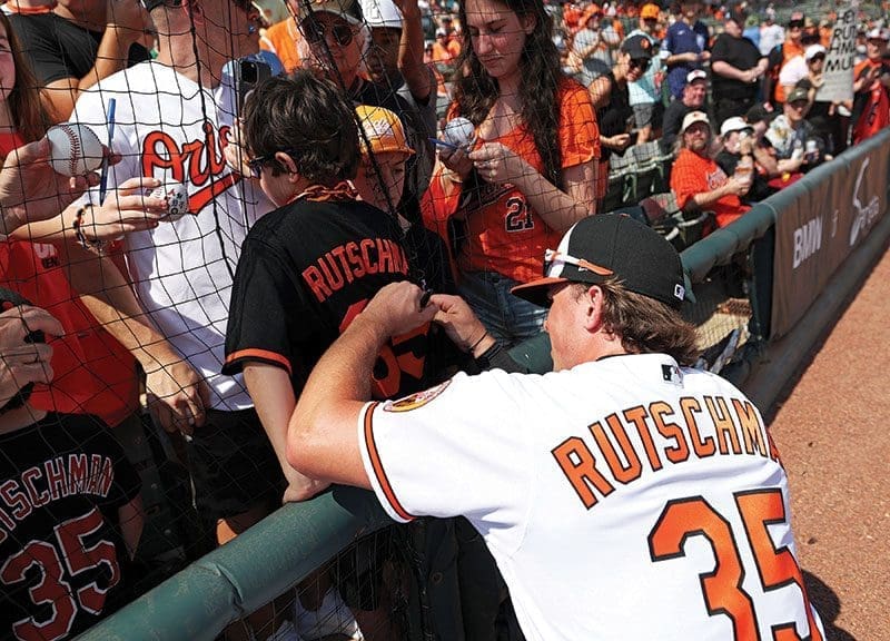 NAME GAME Catcher Adley Rutschman, who was also called up from the Tides to the Orioles in 2022, signs a young fan's shirt. Photo Courtesy of the Baltimore Orioles