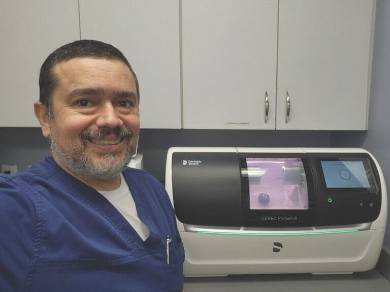 Doctor Jayme Oliveira with 3D printer in the background