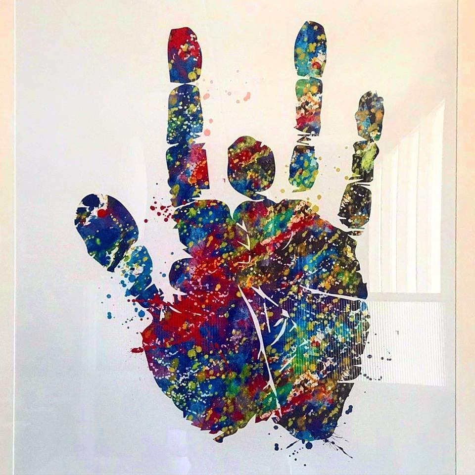 A colorful splatter-paint artwork of a open hand print, with red, blue, and green paint on a white background.