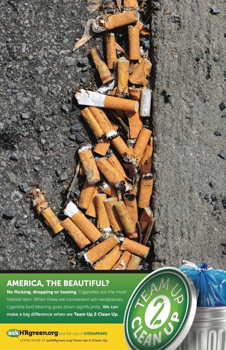 Cigarette butts litter a gray asphalt gutter beside a green "Team Up 2 Clean Up" logo and a trash can with a blue bag.