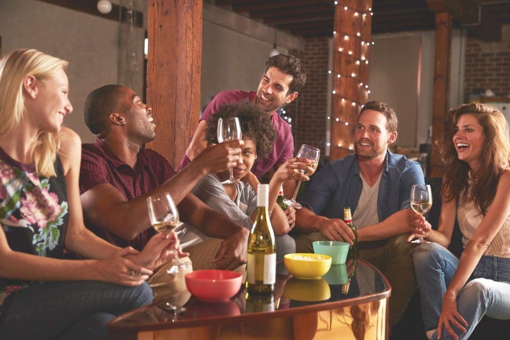 Happy young adults friends having a party at home