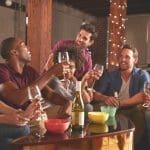 Happy young adults friends having a party at home