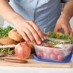 Woman in blue t-shirt preparing a lunchbox in the kitchen