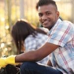 handsome teen volunteer cleaning streets with friends