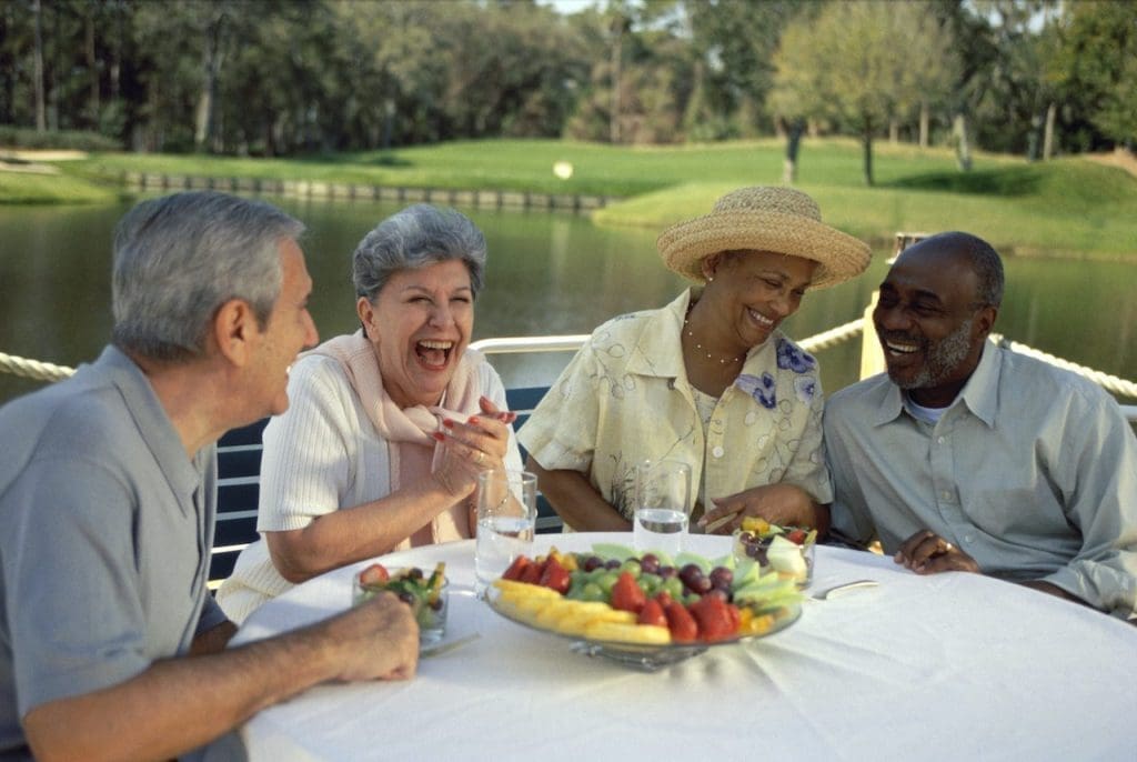 Two senior couples sitting at an outdoor restaurant