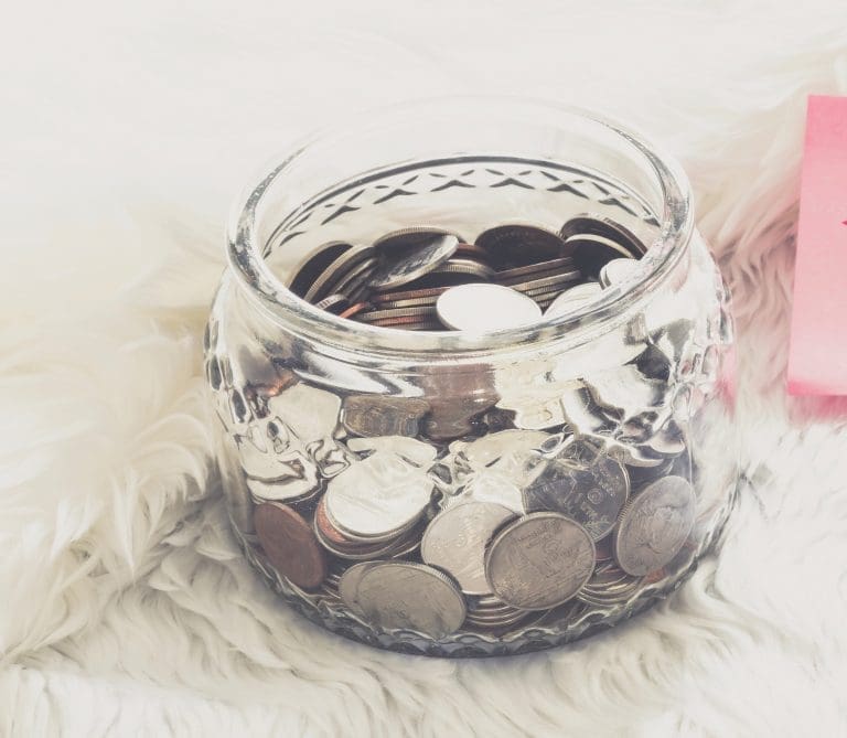 many coins in a money jar with wedding label on jar. wedding concept. saving concept