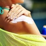 Woman applying sunblock protection on shoulders