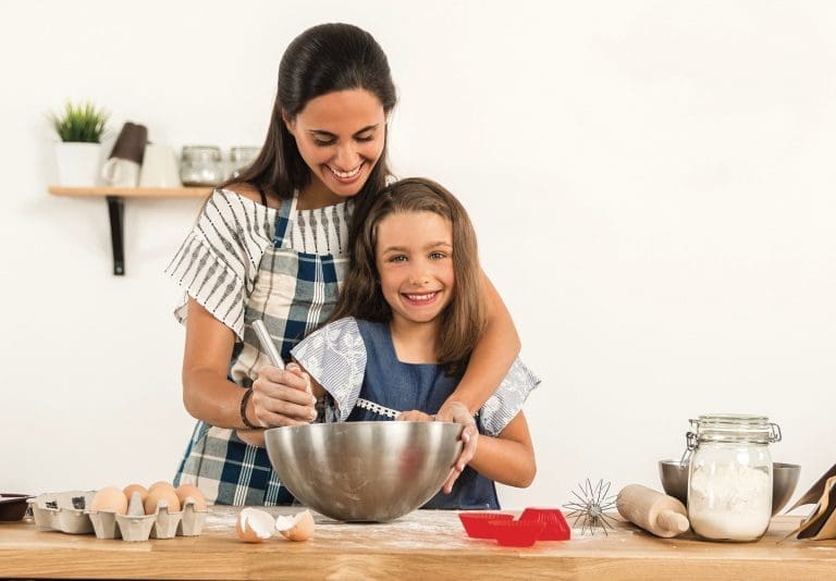 Shot of a mother and daughter having fun in the kitchen and learning to make a cake