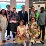 Group posing indoors with two kneeling dancers in colorful Nutcracker costumes, one holding a Richmond Ballet book.