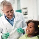 Happy kid on dental chair after repairing tooth