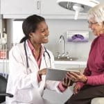 Doctor Discussing Records With Senior Female Patient