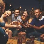 Group Of Friends Enjoying Night Out At Rooftop Bar
