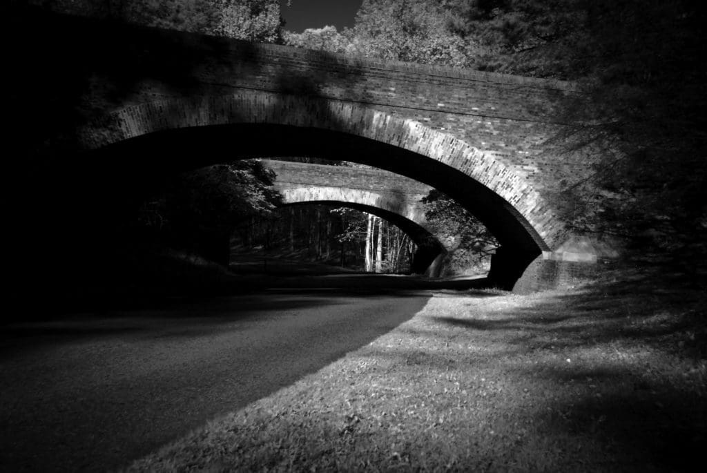 Infrared photograph of two bridges over a cobblestone parkway